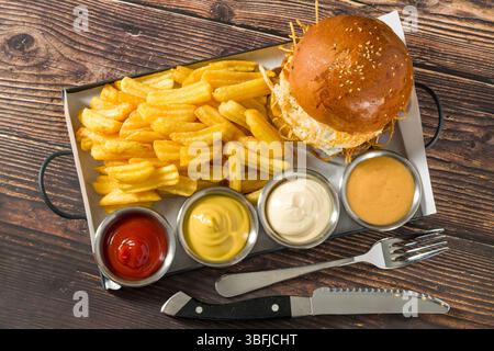Egg burger with crispy potatoes served with fries and sauces Stock Photo