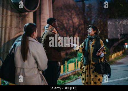 Three individuals engaged in an outdoor evening meeting and handshake in a professional and friendly interaction Stock Photo