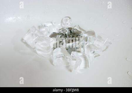 Ice cubes on a plum in a white sink. Stock Photo