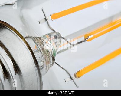 Macro shot of LED Filament type lamp from the base side on white background. Stock Photo