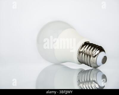 View from the base of the socket on an LED lamp isolated on a white background with reflection. Stock Photo