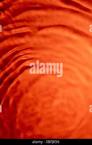 Flowing orange fabric creates a smooth, elegant background Stock Photo