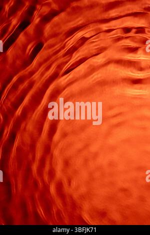 Vibrant orange water surface creating stunning abstract patterns Stock Photo