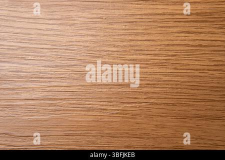 Top-down view of a light brown wooden surface, showcasing its natural grain patterns with horizontal lines and subtle variations in tone. Stock Photo