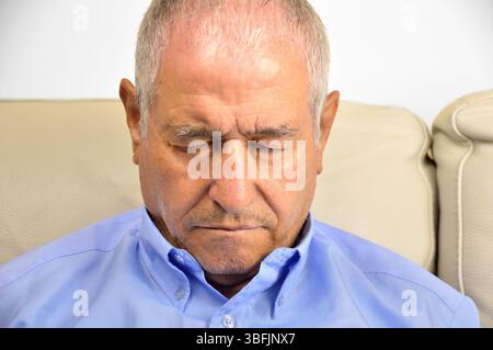 Senio man with sleeping sickness  and resting on a couch at home Stock Photo