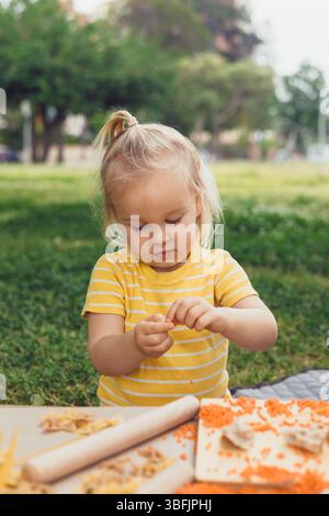 baby hands playing and learning with wooden train set on wooden rails