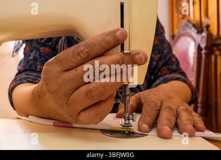 Close up of Old woman hand's using sewing machine Stock Photo