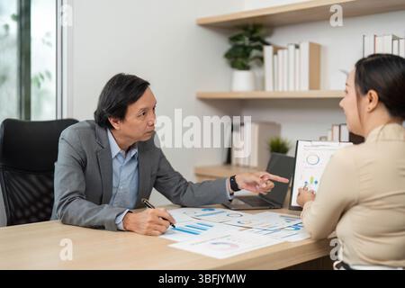 Business Meeting and Collaboration. Professional discussion between two colleagues analyzing data in modern office. Stock Photo