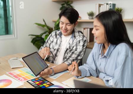 Collaborative UX and UI Design Session. Designers reviewing ideas on a tablet. Stock Photo