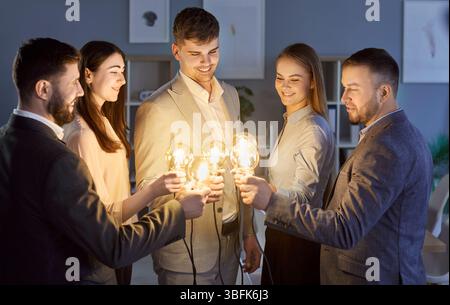 Positive Business Team With Light Bulbs In Office Stock Photo