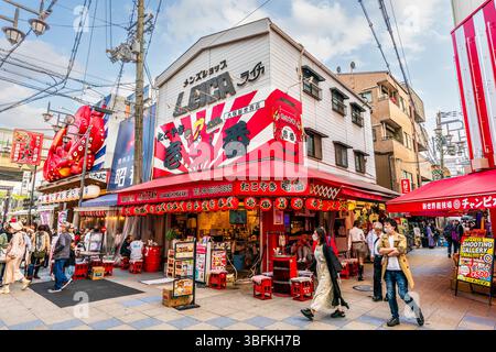The corner Takoyaki Ichiban Osaka Sinsekaiten restaurant in Shinsekai. Large billboard with red octopus above the entrance, people walking past. Stock Photo