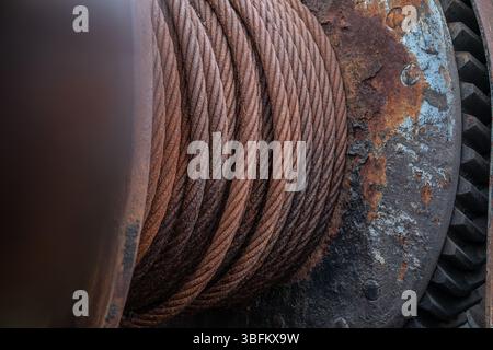 Close-up of rusty steel winch cable and gear mechanism on abandoned shipyard machinery Stock Photo