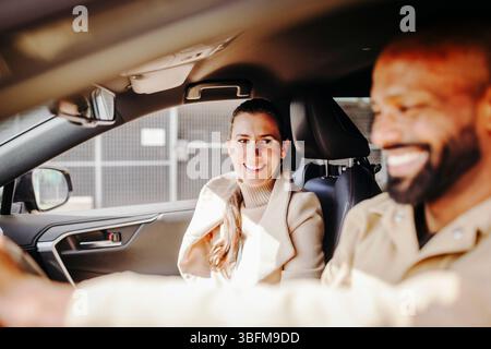 Smiling woman enjoying road trip with man while sitting in car Stock Photo