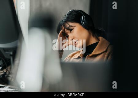 Frustrated female computer programmer at tech start up office Stock Photo