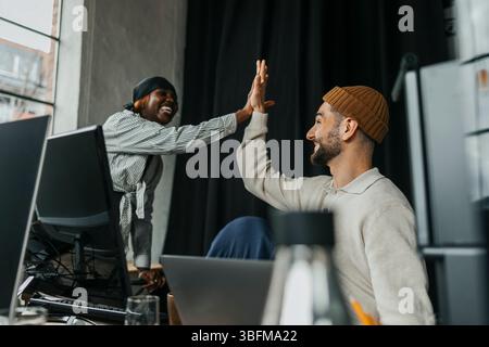 Happy male and female entrepreneurs giving high-five at office Stock Photo