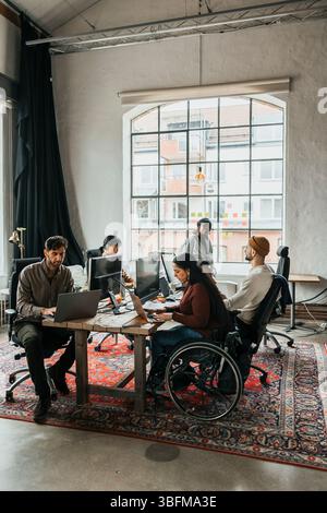 Team of male and computer programmers working at tech start up office Stock Photo