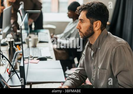 Focused programmer working on computer at tech start up office Stock Photo