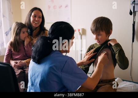 Doctor examining patient with stethoscope in medical clinic Stock Photo