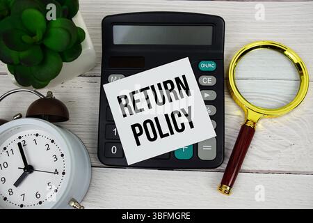 Return Policy text message with calculate, alarm clock and magnifying glass on wooden background Stock Photo