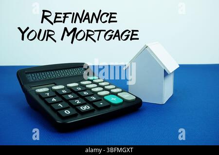 Refinance Your Mortgage text with White house model with calculator on navy blue background, mortgage and properties concept Stock Photo