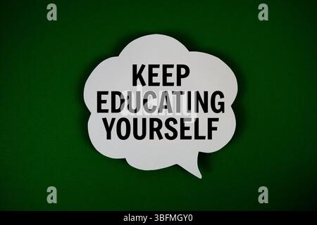 Keep Educating Yourself text with speech bubble on green background Stock Photo