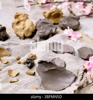 Creating Clay Flower: DIY ceramic Workshop Idea. Petals, buds prepared for crafting different spring flowers from dark and yellow clays on fabric. Lig Stock Photo