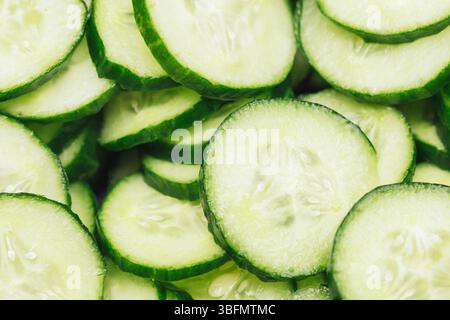 Fresh cucumber slices background. Green vegetable pattern. Healthy organic food texture. Sliced cucumber close-up. Natural salad ingredient. Stock Photo