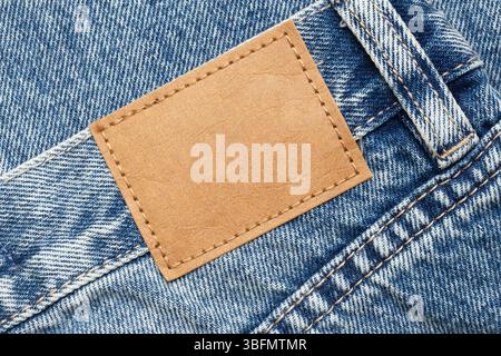 Denim jeans pocket with leather label. Fashion detail macro. Casual clothing texture. Modern outfit design. Clothing manufacturing close-up. Stock Photo