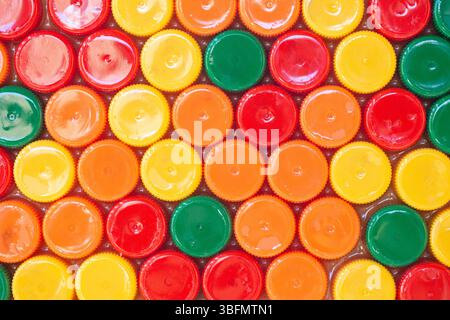 Colorful bottle caps background. Bright plastic pattern. Recycling concept. Plastic waste texture. Top view of round colorful lids. Stock Photo