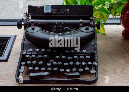 Tromso, Norway, 05.16.2025. A very old, dusty and broken Remington typewriter standing on the window sill of a restaurant. Norwegian keyboard Stock Photo