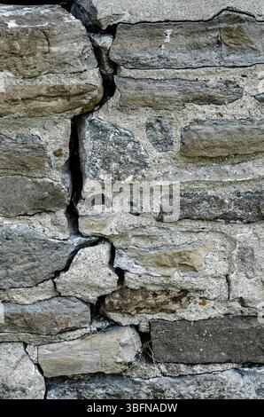 Close-up of a vertical crack in an old stone wall Stock Photo
