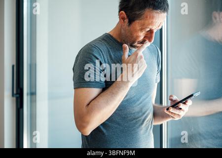 Reading worrying text message on mobile phone, selective focus Stock Photo