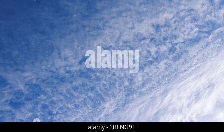 High altitude wispy white cirrocumulus clouds on blue sky, Finland Stock Photo