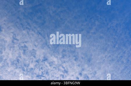 High altitude wispy white cirrocumulus clouds on blue sky, Finland Stock Photo