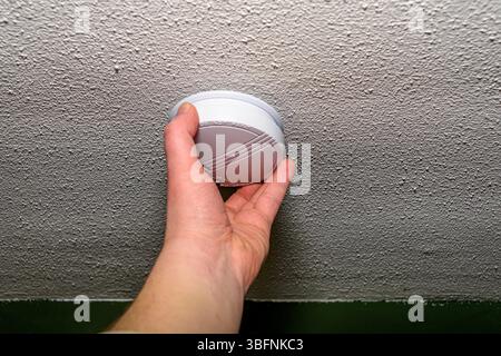 Man installing smoke detector Stock Photo