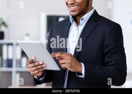 Happy african american businessman using digital tablet Stock Photo
