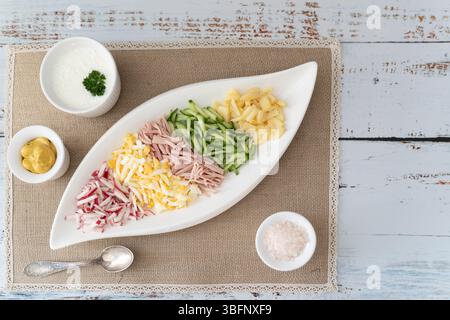 A flatlay of diced vegetables and herbs for okroshka, with kefir and mustard Stock Photo