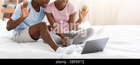 Cheerful black couple having online party, using laptop Stock Photo