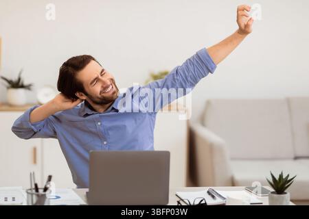Man Massaging Aching Neck After Work At Computer In Office Stock Photo