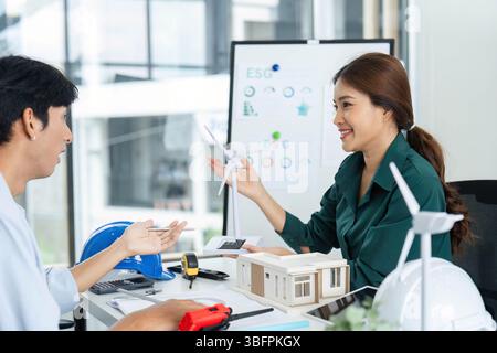 ESG Focus. Engaging discussion between two professionals on sustainable architecture and energy solutions. Stock Photo