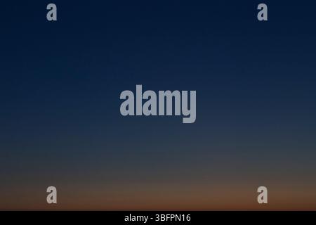 Orange and dark blue cloudless sky in the evening. Abstract natural landscape and background with copy space. Stock Photo