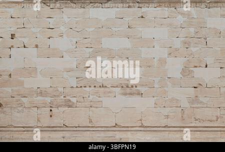 Smooth, weathered & cracked ancient wall made of stone blocks in Athens, Greece, viewed from the front. High resolution full frame textured background Stock Photo