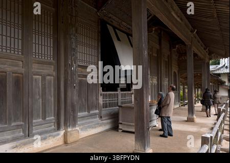 Worshipers praying at the hondo (main hall) of the Zen Buddhist temple Tokoji in Hagi, Yamaguchi, Japan. Stock Photo