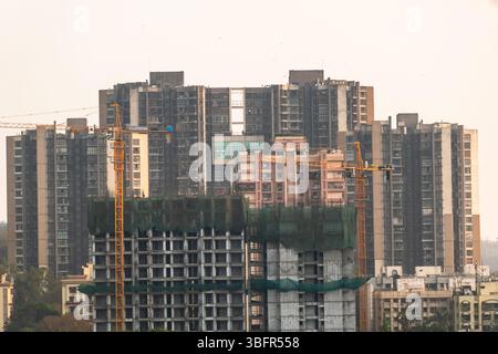 High-rise buildings are under construction in Mumbai, with cranes actively working on site. Stock Photo