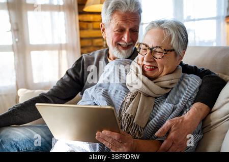 Elderly couple enjoying a tablet. Senior man and woman smiling, bonding over technology. Stock Photo