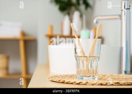 Holder of toothbrushes near sink on table in bathroom Stock Photo