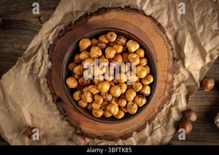 Shelled hazelnuts filling a bowl on a wooden boardShelled hazelnuts filling a bowl on a wooden board Stock Photo