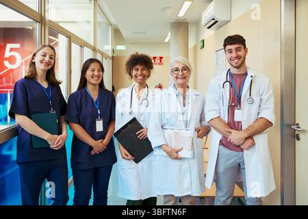 Medical team smiling in hospital corridor: doctors and nurses collaborative healthcare Stock Photo