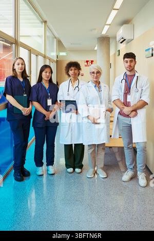 Medical team posing in hospital corridor, healthcare professionals united Stock Photo