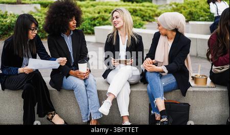 Business women talking during lunch break outdoor from office building - Colleagues day lifestyle and food concept concept - Main focus on blond girl Stock Photo